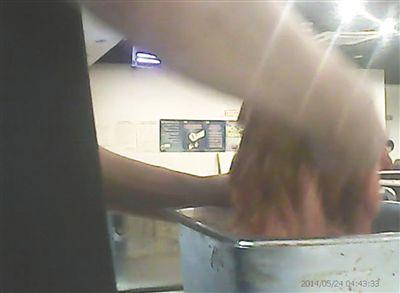 在開餐前，烤肉店一名員工正徒手攪拌肉片。
